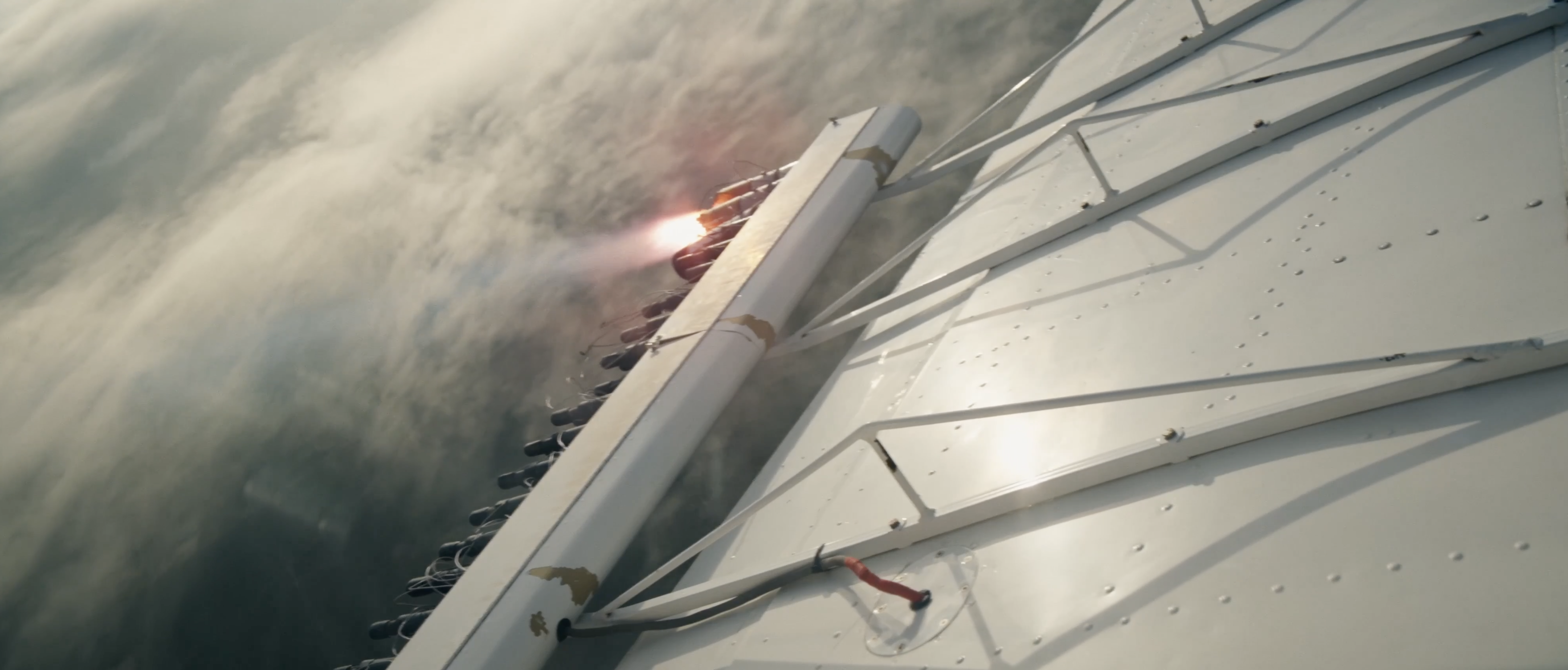 A flare burning in the cloud seeding rack mounted on an aircraft wing